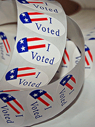 roll of colorful "Voted" Stickers on a table