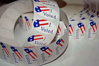 roll of colorful "Voted" Stickers on a table